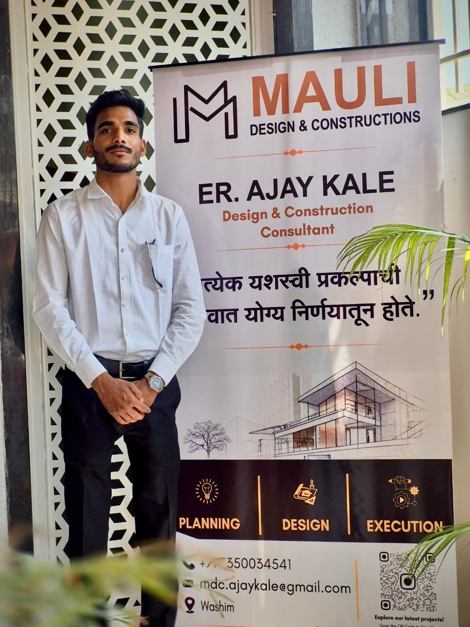 Ajay Kale standing next to the Mauli Design & Constructions office signboard in Washim